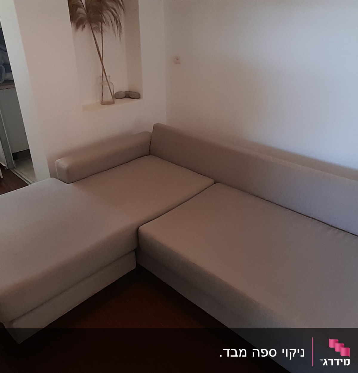 ספה אפורה בחדר עם רצפת עץ